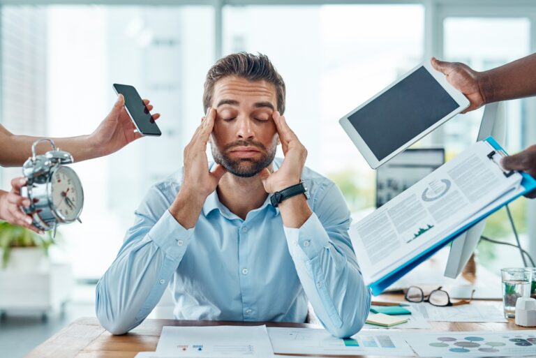tired and stressed out man with his hands on his head, burned out office worker