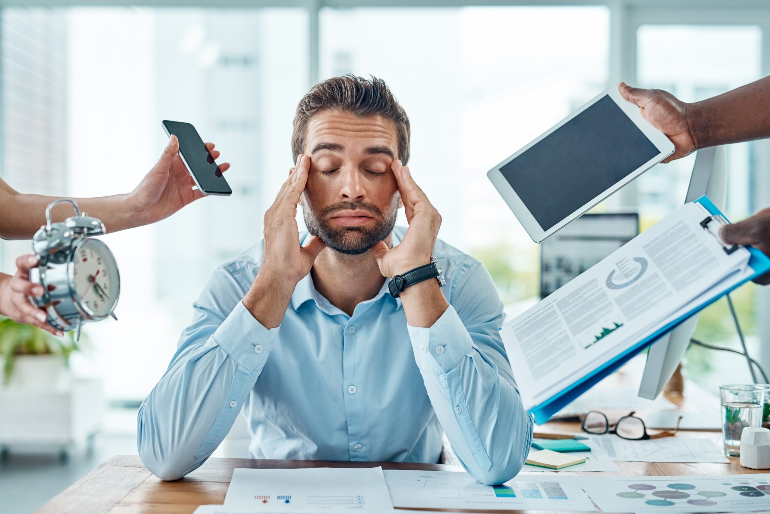 tired and stressed out man with his hands on his head, burned out office worker
